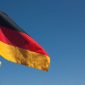 Hand is holding the germany flag against blue sky